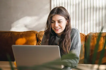 Junge Frau arbeitet morgens am Laptop – moderner Kundenservice und digitale Energieangebote der EV Greiz