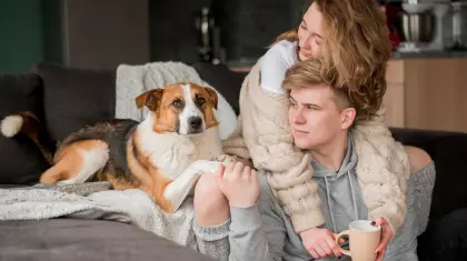 Junges Paar mit Hund auf dem Sofa – wohlige Wärme im Zuhause dank effizienter Fernwärme von EV Greiz