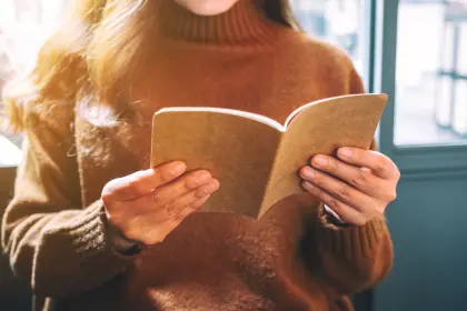 Eine junge Frau liest das Kundenmagazin der EV Greiz in gemütlicher Atmosphäre.