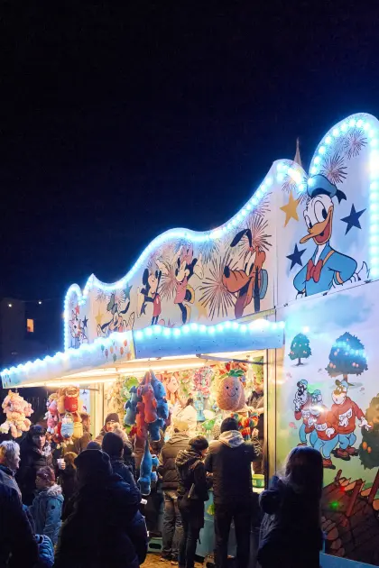 An einer bunt beleuchteten Spielbude kann man zahlreiche tolle Preise gewinnen.